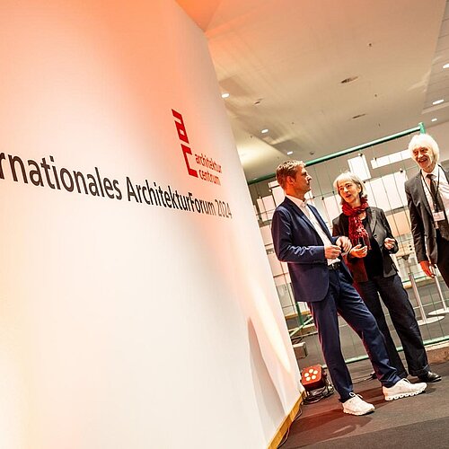 Zwei Männer und eine Frau sprechen mit einander.