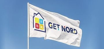 Eine rectangle Flag mit der Aufschrift Get Nord ist vor einem blauen Himmel zu sehen. 